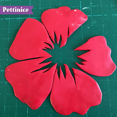 Alternate cut outs as shown, with some taller cuts than others.  once you have done all 5 petals make sure you cut extra away from the sides of one petal to leave room for the stamen.
