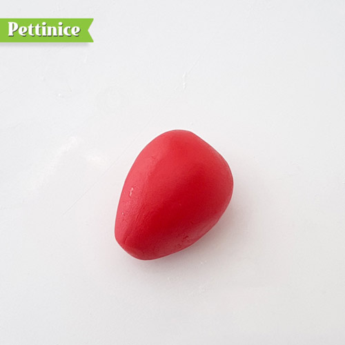 Take a red ball of fondant, use your fingers to roll in to taper in the bottom making a strawberry shape.