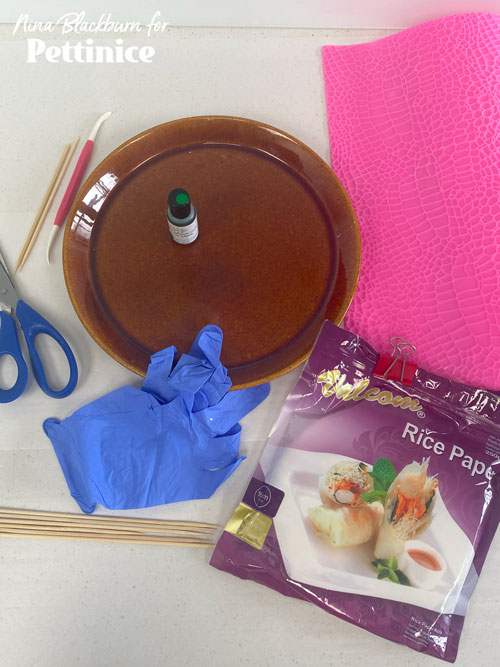 You will need a shallow plate, rice paper, food colouring, scissors, toothpicks, and a silicon mat.
