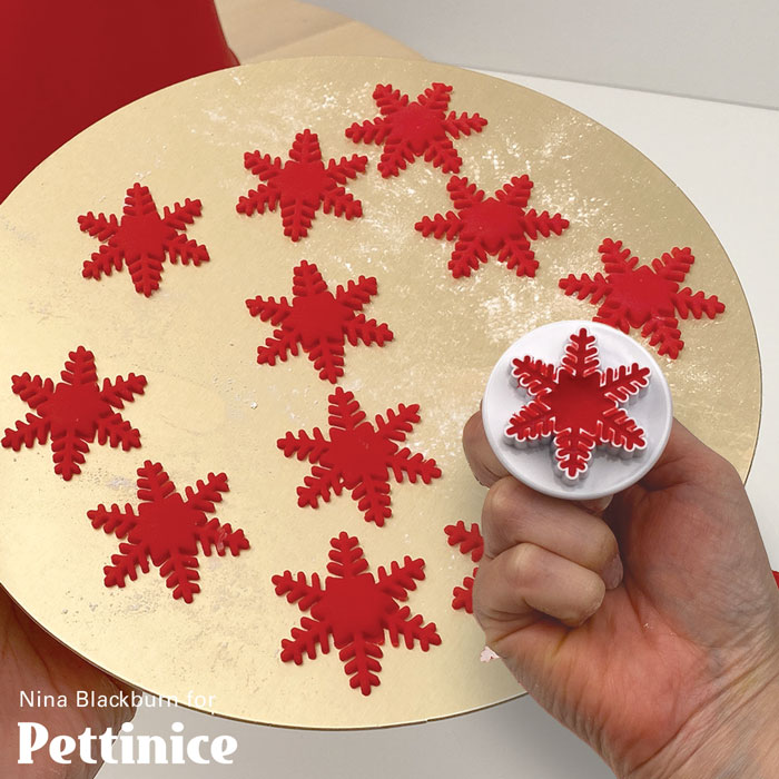 Pat a cake disk with cornflour. Roll and stamp out heaps of snowflakes.  Harden in the freezer.