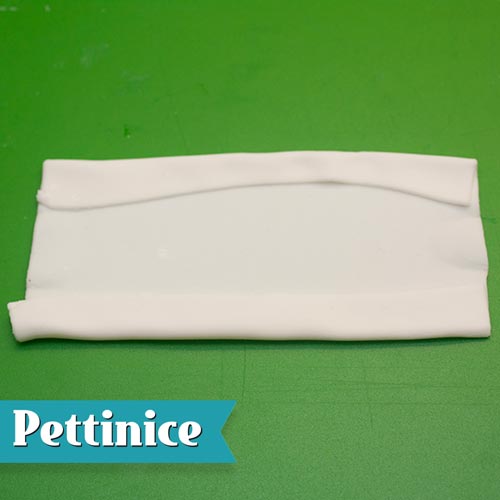 Roll another rectangle of the white fondant about 1cm longer than the swag template length and about 5-6cm wide.  Brush both edges with a little sugar glue and fold both in as shown.