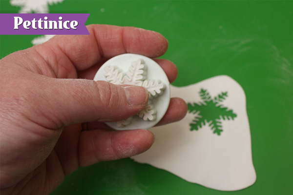 Roll white fondant  thinly & cut a couple of snowflakes.