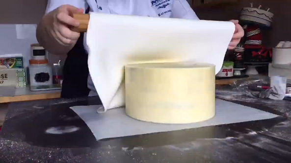 Use your rolling pin to help you place the fondant over the cake.