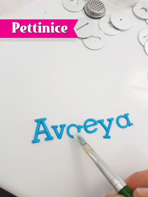 Dab your paint brush with crisco and pick up the middle letter with the paintbrush and apply it to the centre point of your cake.