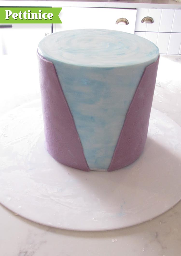 Once the painted surface of the cake is dry, attach the fondant piece you have cut out around the cake with a little sugar glue or water.