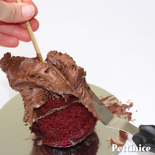 You can use a kebab stick to hold your cupcakes in place while you ice them.  Completely ice and smooth and set aside.