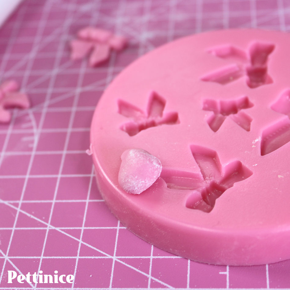 Pat a little icing sugar or cornflour onto a little ball of Petitnice before placing into the bow mold.  This will help it from sticking.