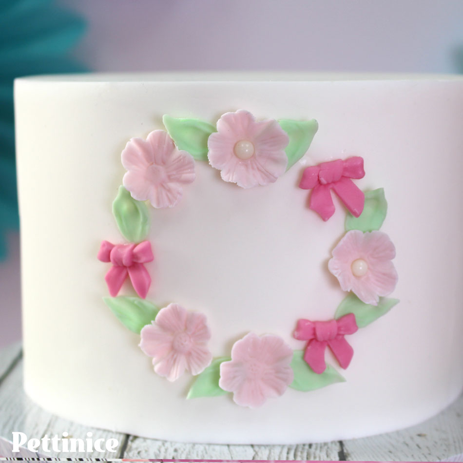 Continue building up your Floral frame with your bows and add some of the pearl sprinkles in the centre of your flowers..