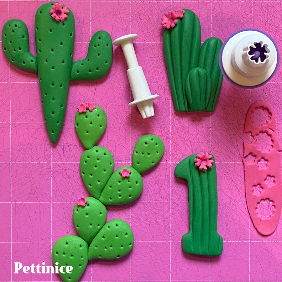 Roll out a small piece of pink fondant, cut out a few pink blossoms and stick them to the cacti using a little water or edible glue.