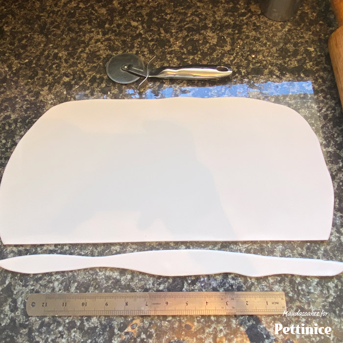 Cut a straight edge along the length of the sheet, making sure you still have enough to cover the height of the cake.