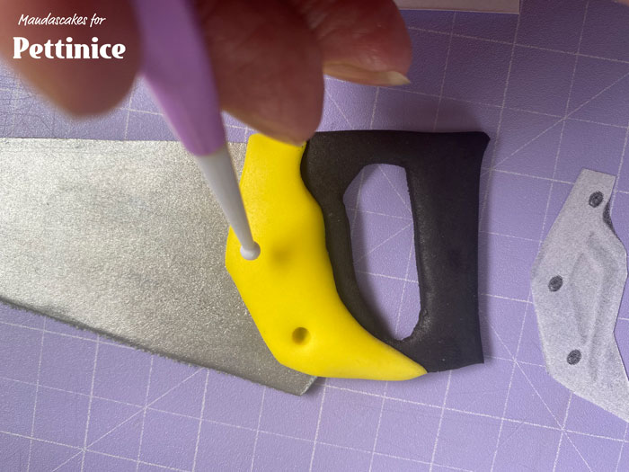 .  Make a few small indents using a ball tool, and fill with black dots of fondant.