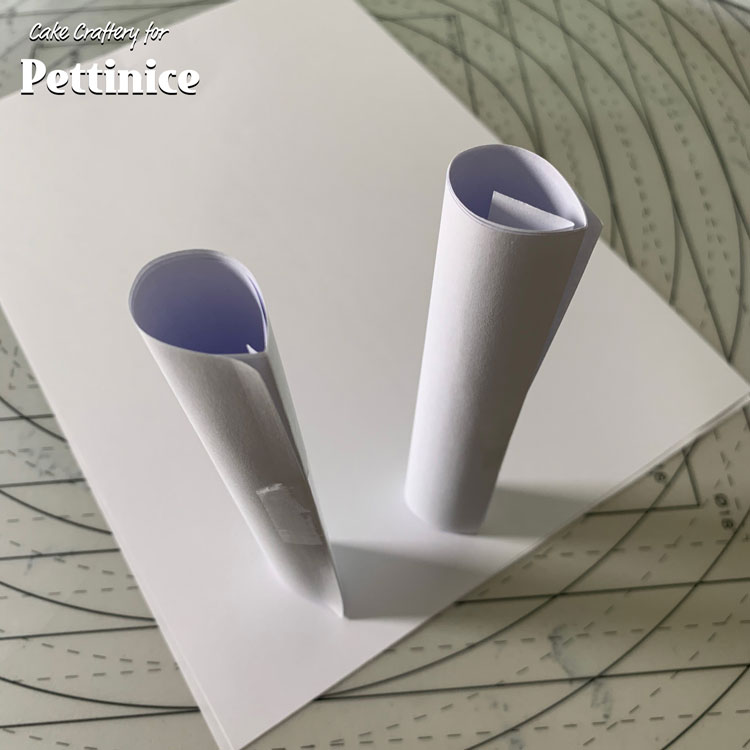 Start by making the bow-tie. Roll 2 paper tubes into 2cm diameter rolls. Press a crease into one side of each roll to make it teardrop shaped.
