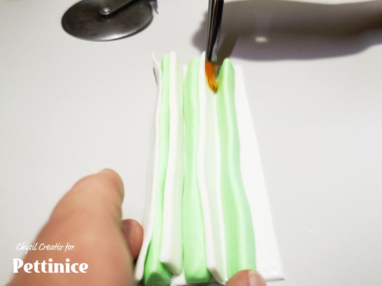 Lay your flat white strip down, and alternate between the strips you cut earlier and your triangle shapes.