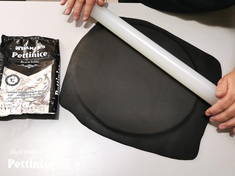 Roll out your black Pettinice and place over your cake board.  To make sure it's totally smooth, I roll it on the board a few times too.  Trim the edges.