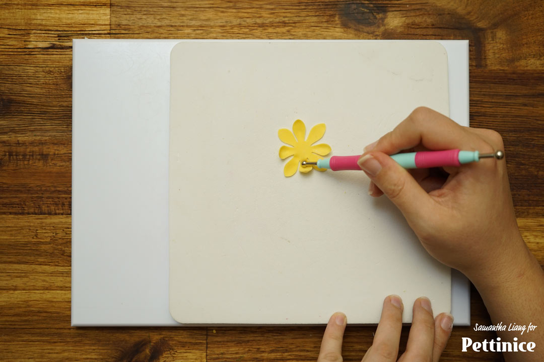 Curl a few petals inward using a dresden tool or small ball tool. Turn the petals over and curl the other petals inward. This will give your flower natural movement.