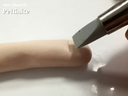 Using your flat tipped tool make indents for the nail and wrinkles and creases for the finger