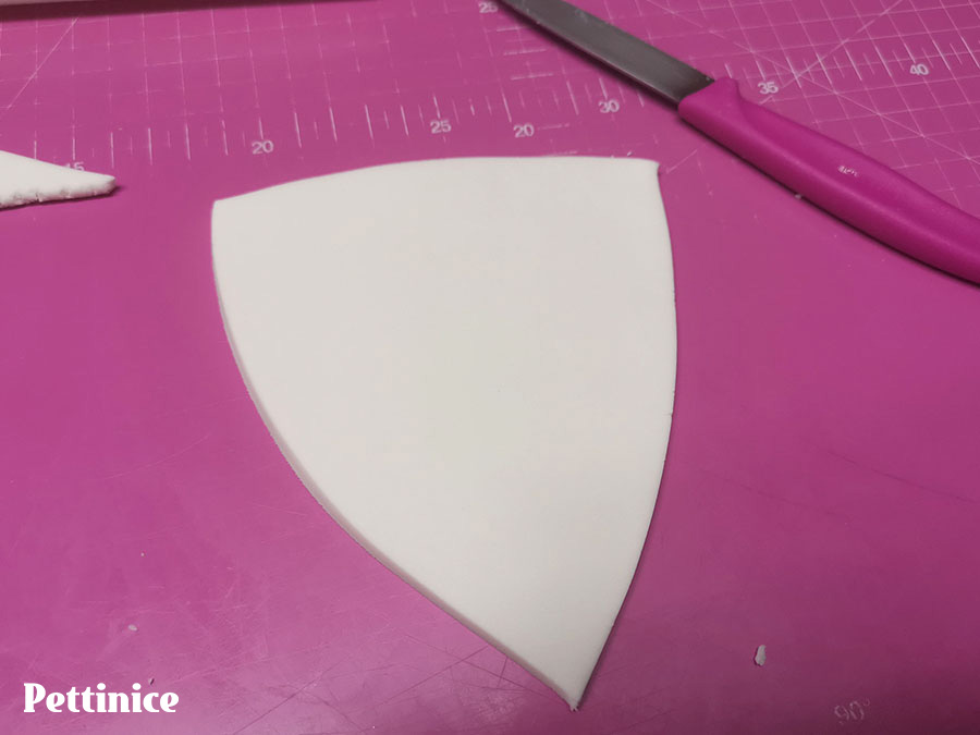 Cut into a triangular shape that would fit his chest. You can measure it against the cake before the next step.
