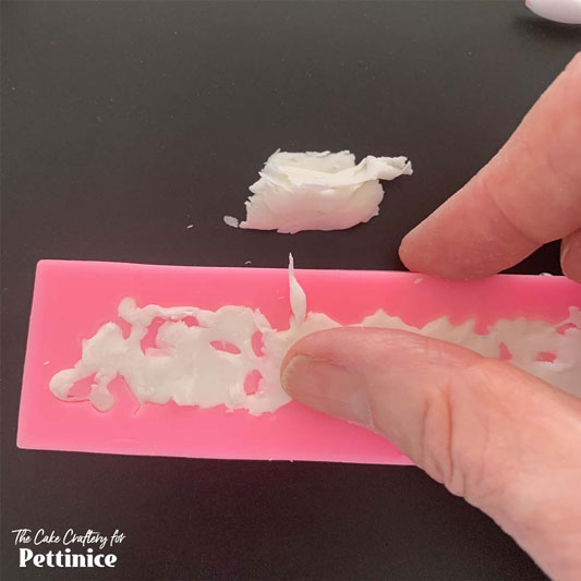 Prepare 100 g of white Pettinice with a half-teaspoon of Tylose powder. Spray your chosen mould lightly with some canola oil spray and start pressing Pettinice into it. I like to rub off the excess with my thumb. A blunt blade could also be useful but don’t damage your mould.