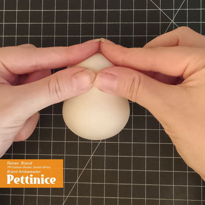 You will now be creating the nose by slowly pinching and pulling the fondant.
