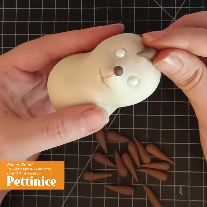 Using edible glue, start by adding 3 "spikes" centre on the top of his head