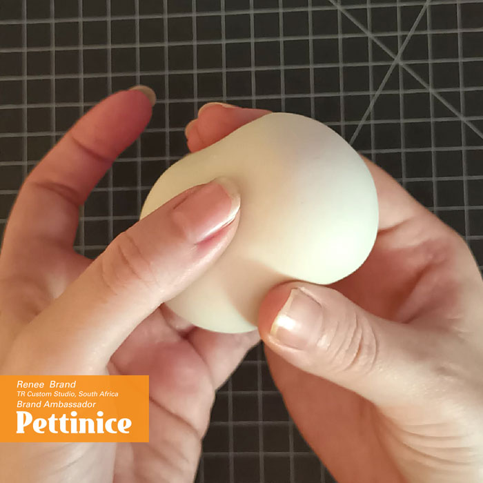 Press your round ball in the middle and create an hour glass shape. You will need to work fast with your  Fondant to prevent it from creating wrinkles).